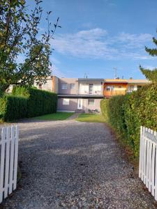dom z białym płotem i podjazdem w obiekcie Trenta Apartman Bükfürdő w mieście Bük