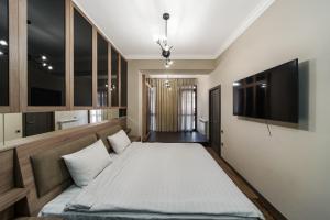 1 dormitorio con 1 cama y TV de pantalla plana en One-BDR Luxury apartment, en Ereván