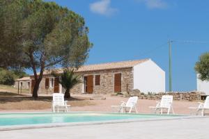 een groep witte stoelen rond een zwembad bij Stazzo Gallurese La Cugara in Aglientu