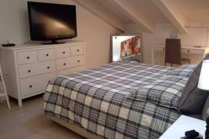 Schlafzimmer mit einem Bett und einem Flachbild-TV in der Unterkunft Casa annuale al mare a Jesolo! in Lido di Jesolo