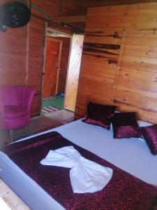 uma cama grande num quarto com paredes de madeira em Posada chikiluky beach em Playa Blanca