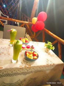 a table with two bowls of fruit and drinks on it at Posada chikiluky beach in Playa Blanca