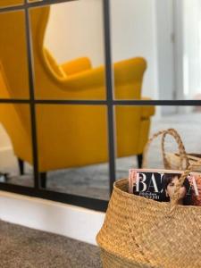a basket with a picture of a yellow chair in front of a mirror at Santiago Suite 4 - A Beautiful Duplex Flat in Southport