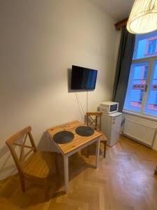 a living room with a table and a tv at Cosy central apartment in Žižkov in Prague