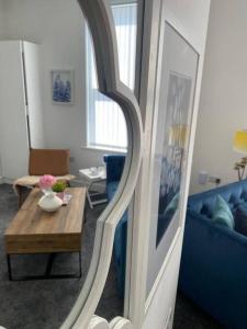 een woonkamer met een tafel en een blauwe bank bij Santiago Suite 4 - A Beautiful Duplex Flat in Southport