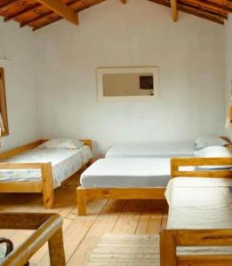 a bedroom with two beds and a table and chairs at Blue House Vale do Capão in Palmeiras