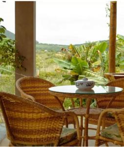 uma mesa e cadeiras num quarto com uma janela em Blue House Vale do Capão em Palmeiras
