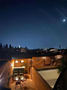 una vista su un balcone di notte con tavolo e sedie di Riad El Youssoufi a Marrakech