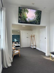 uma sala de estar com uma televisão de ecrã plano na parede em Old Bank Apartment em Motueka