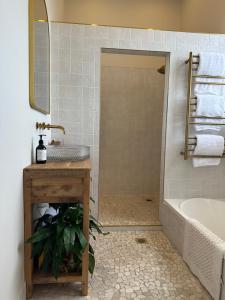 a bathroom with a shower and a sink and a tub at Old Bank Apartment in Motueka