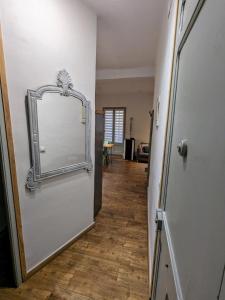 un pasillo con un espejo en una pared blanca en Precioso y acogedor piso en la Seu de Urgell, en La Seu d'Urgell