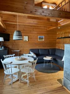 ein Wohnzimmer mit Sofa, Tisch und Stühlen in der Unterkunft Yllästölli 2 A, Äkäslompolo in Kolari