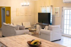 a living room with couches and a flat screen tv at The Nest Villa, A Dream Escape for the entire family in Golden Grove