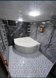 y baño con bañera grande y ducha. en Nippon Hotel, en Samarkand
