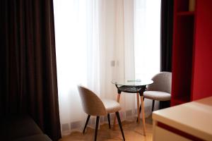 ギュムリにあるBARBAR APART HOTELのテーブルと椅子2脚、窓が備わる客室です。