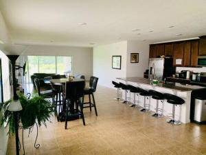 a kitchen with a bar with black chairs and a counter at Single Family Home Near Disney. New Management in Davenport