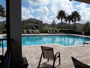 a swimming pool with chairs in a resort at Single Family Home Near Disney. New Management in Davenport