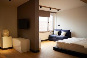 una camera con un letto e un divano blu di BARBAR APART HOTEL a Gyumri