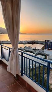 a view of the ocean from a balcony with a curtain at Light Blue in Makry Gialos