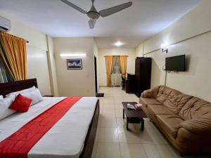 Habitación de hotel con cama y sofá en Hotel Rooms DHA en Karachi