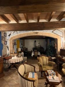 La Frasca في Coltaro: غرفة معيشة مع كراسي وطاولات وجدار حجري
