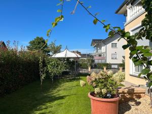 un jardín con sombrilla y algunas plantas en un patio en FeWo-Orion,nahe Europapark & Rulantica,Netflix,Disney,KartinaTV, en Mahlberg