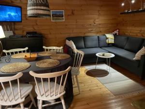 ein Wohnzimmer mit Sofa, Tisch und Stühlen in der Unterkunft Yllästölli 2 A, Äkäslompolo in Kolari