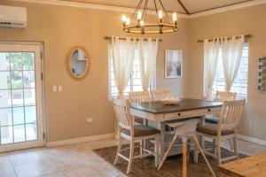 a dining room with a wooden table and chairs at The Nest Villa, A Dream Escape for the entire family in Golden Grove