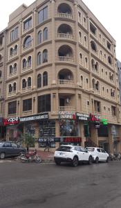 a large building with cars parked in front of it at Northern Suites Bahria town in Rawalpindi