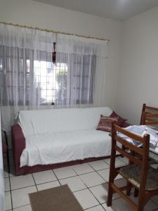 a white bed in a room with a window at Apartamento 1 in Florianópolis