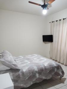 a bedroom with a bed and a ceiling fan at Apartamento 1 in Florianópolis