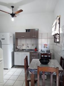 a kitchen with a table and chairs and a refrigerator at Apartamento 1 in Florianópolis