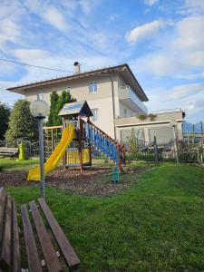 un parque infantil frente a una casa con tobogán en Cinzia Dolomiti del Brenta, en Tassullo