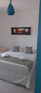 a bedroom with two beds and a picture on the wall at Pousada Mediterrânea in Pipa