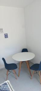 a white table and two blue chairs in a room at Pousada Mediterrânea in Pipa