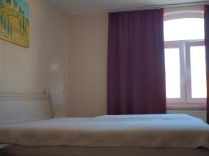 - une chambre avec un lit, une fenêtre et un couvre-lit dans l'établissement Jarmen Ferienwohnung, à Jarmen