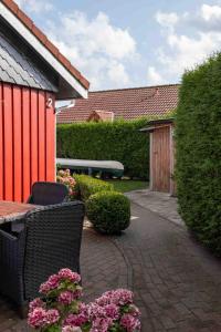 a patio with a table and chairs and flowers at Suedseeurlaub2 - Ferienhaus in Otterndorf in Otterndorf