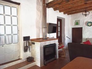 ein Wohnzimmer mit einem Kamin und einem TV in der Unterkunft El Lucero in Alájar
