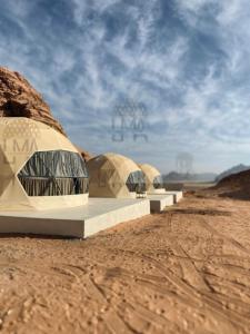 a row of domes in the desert under a blue sky at Lma Luxury Camp in Wadi Rum
