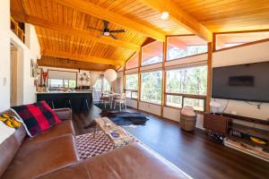 uma sala de estar com um sofá e uma televisão de ecrã plano em Yosemite A-Frame Haven - Nature's Embrace for Remote Work or Relaxation em Groveland