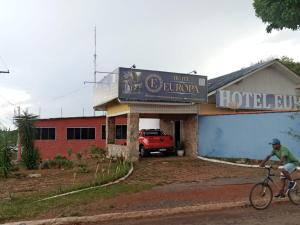 um homem a andar de bicicleta em frente ao átrio do hotel em HOTEL EUROPA FAMILIAr em Alto Paraíso de Goiás