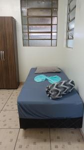 een slaapkamer met een blauw bed met een handdoek erop bij Pousada cantinho da felicidade in Uberlândia