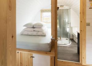 uma cama num quarto com uma porta de vidro em Spectacular Mountain View Ecopod em Newtonmore