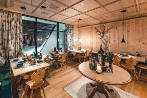 um restaurante com paredes e mesas e cadeiras de madeira em LUX ALP CHALET am Arlberg em Warth