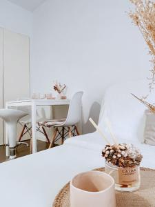 a white living room with a table and a cup of coffee at Alojamiento Vilardell in Barcelona