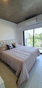 a large bed in a room with a large window at DEPTO LAVALLE 1191 PLAZA BELGRANO in San Miguel de Tucumán