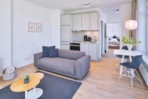 una sala de estar con un sofá y una mesa en Lüttjeod Apartmentvilla 01, en Langeoog 11 fotos más