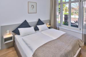 Un dormitorio con una gran cama blanca con almohadas azules. en Lüttjeod Apartmentvilla 01, en Langeoog