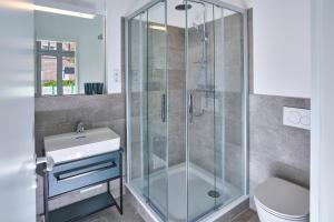 un baño con ducha y lavabo en Lüttjeod Apartmentvilla 01, en Langeoog