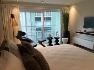 a bedroom with a large bed and a large window at Sleep at Sea in Nieuwpoort